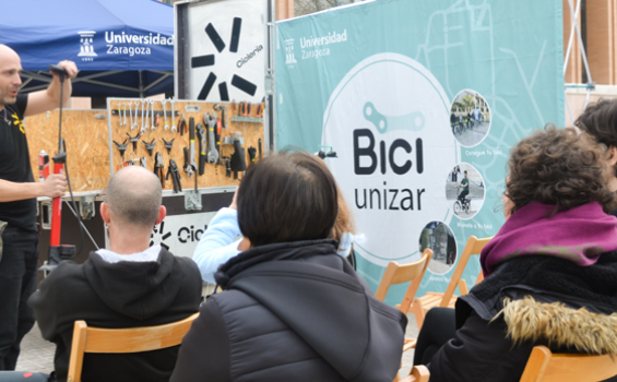 Gente atendiendo a un curso de mecánica para la bici en la calle