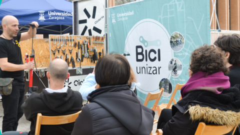 Gente atendiendo a un curso de mecánica para la bici en la calle